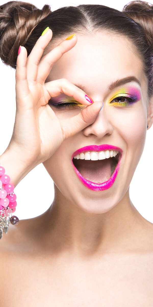 Beautiful girl in pink sunglasses with bright makeup and colorful nails. Beauty face. Picture taken in the studio on a white background.
