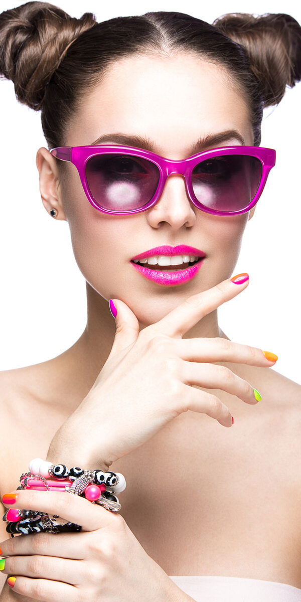 Beautiful girl in pink sunglasses with bright makeup and colorful nails. Beauty face. Picture taken in the studio on a white background.