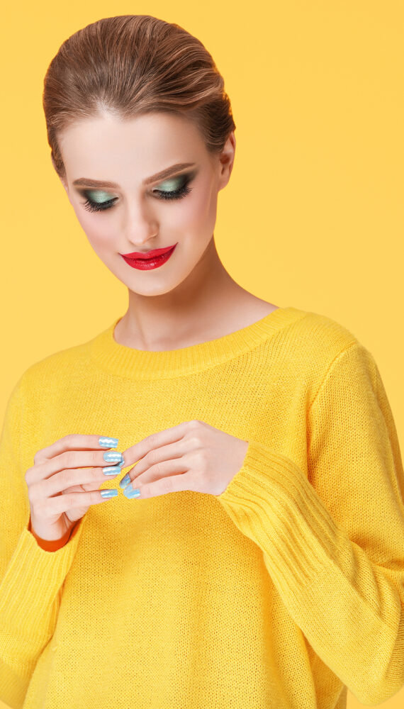 Colorful makeup woman in yellow clothes on color happy summer fashion background
