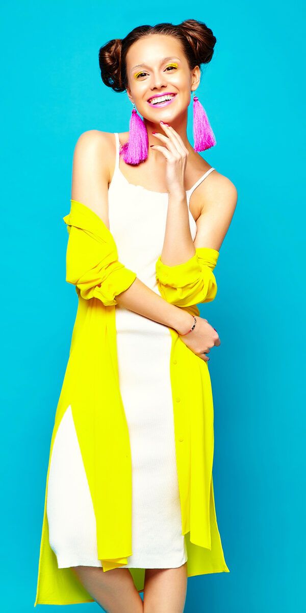 portrait of cheerful fashion hipster girl in casual colorful vivid hipster yellow summer clothes on blue background