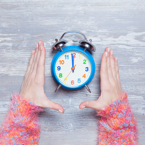 female-hands-holding-clock-on-a-table-2024-09-25-07-51-30-utc