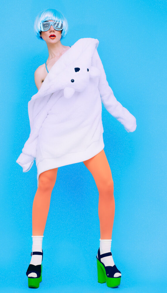 funny fashion girl in hoodie and colored tights on a blue background