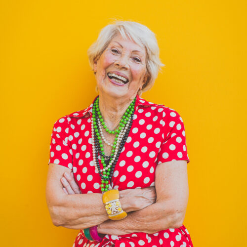 Funny grandmother dancing on colored background