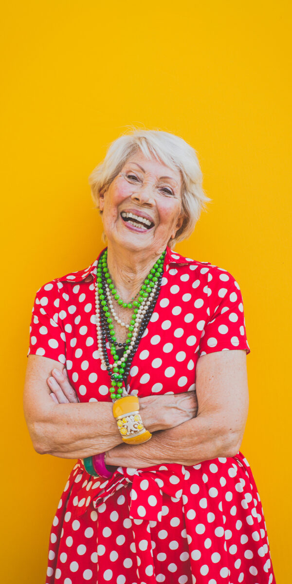Funny grandmother dancing on colored background