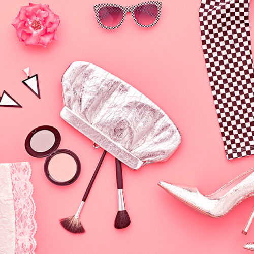 Glamor cosmetics makeup product flying in air cutout minimal. Woman make up collection falling on apricot background. Trendy fashionable layout. Cosmetology make-up advertising, top view.