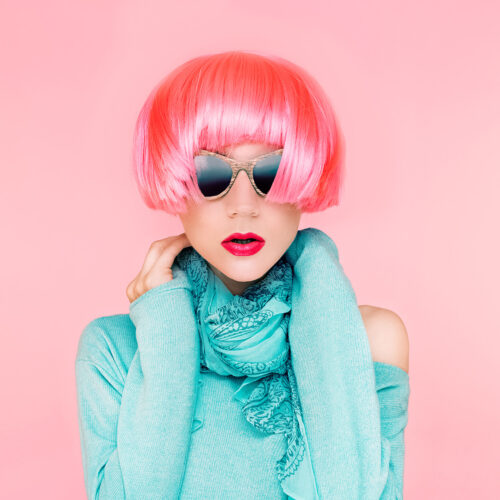 Glamorous fashion lady in pink wig on pink background