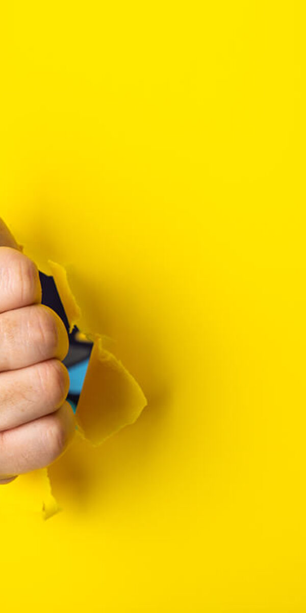 hand-showing-a-thumb-up-sign-through-a-ripped-hole-2023-11-27-05-11-12-utc