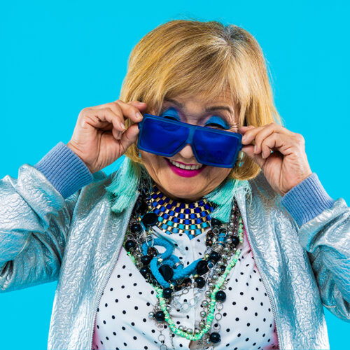 Happy and funny senior old woman wearing fashinable clothing on colorful background- Modern cool fancy grandmother portrait, concepts about elderly and older people