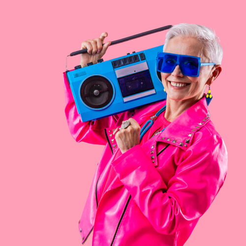 Happy and funny senior old woman wearing fashinable clothing on colorful background- Modern cool fancy grandmother portrait, concepts about elderly and older people