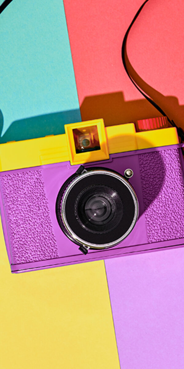 Minimal fashion trendy film camera, summer vibration on vivid geometry background. Hipster accessory look. Stylish creative fashionable vibes. summertime advertising concept, top view