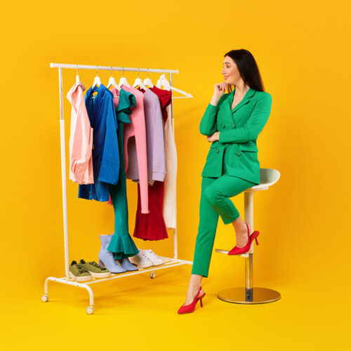 pensive-young-stylish-lady-looking-at-garment-rack-2023-11-27-05-11-36-utc