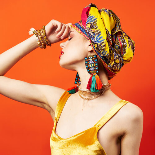 pretty woman ethnicity multicolored headscarf makeup glamor red background. High quality photo