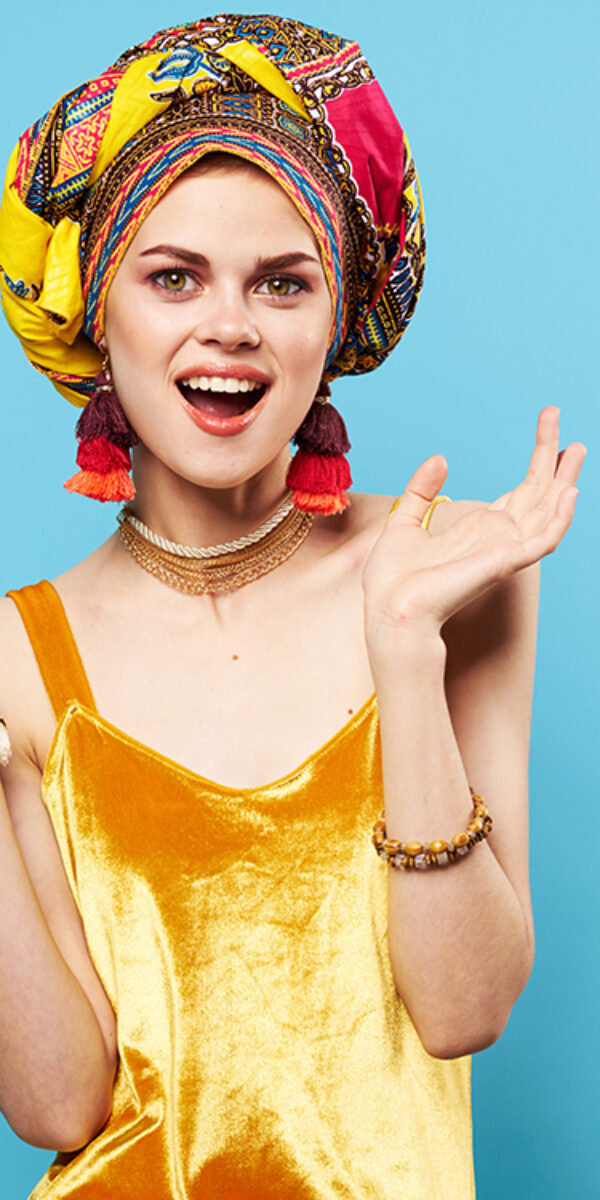 pretty woman in multicolored turban attractive look Jewelry smile Studio Model. High quality photo
