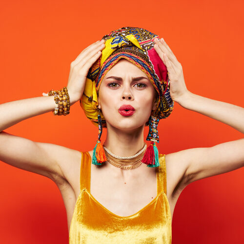 pretty woman multicolored turban decoration red lips attractive look red background. High quality photo