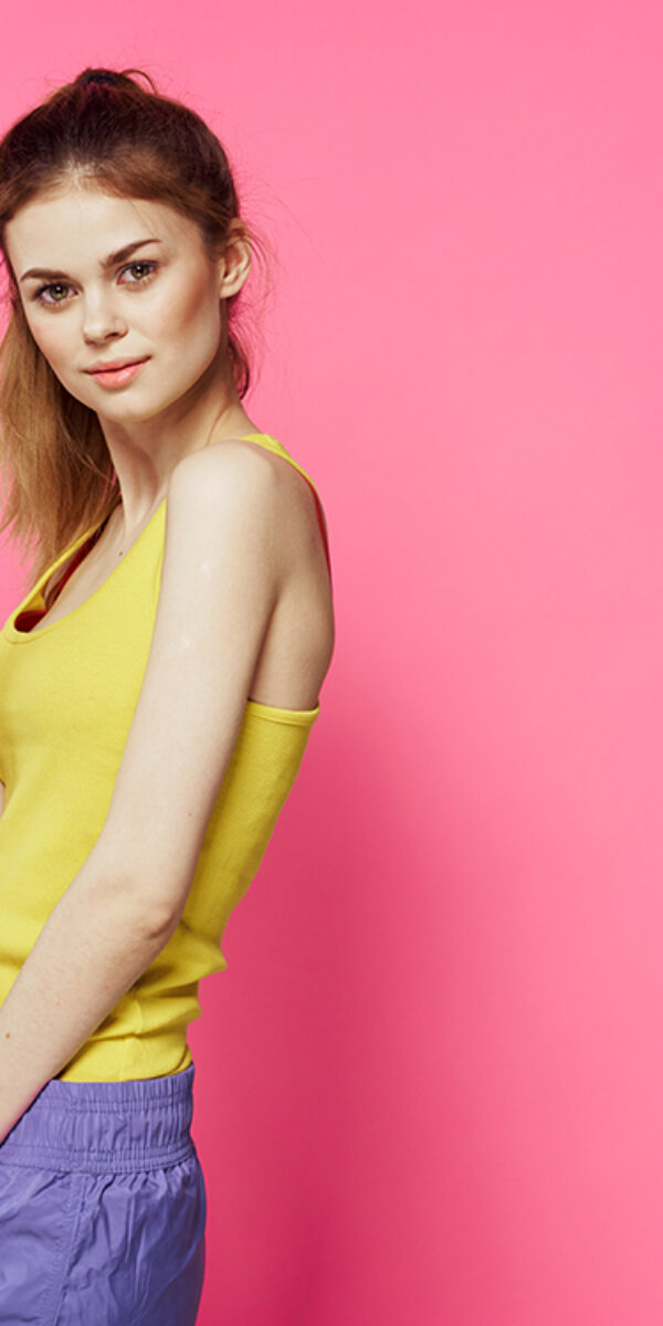 Sportive woman jumping rope friend exercise yellow tank top workout pink background. High quality photo