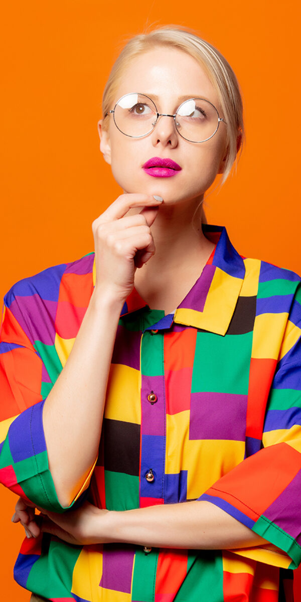 Style blonde in 90s shirt and glasses on orange background