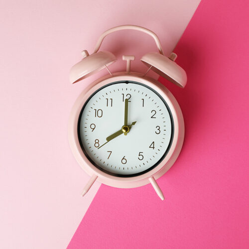 Stylish alarm clock on two tone background