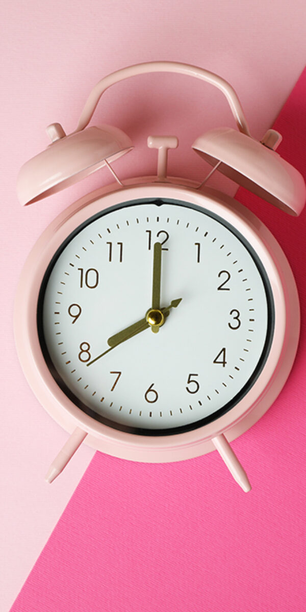Stylish alarm clock on two tone background