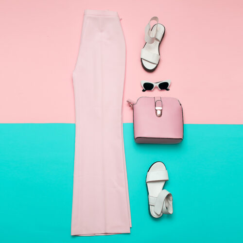 Stylish pink clothing for ladies. Fashion trousers and accessories. Top view