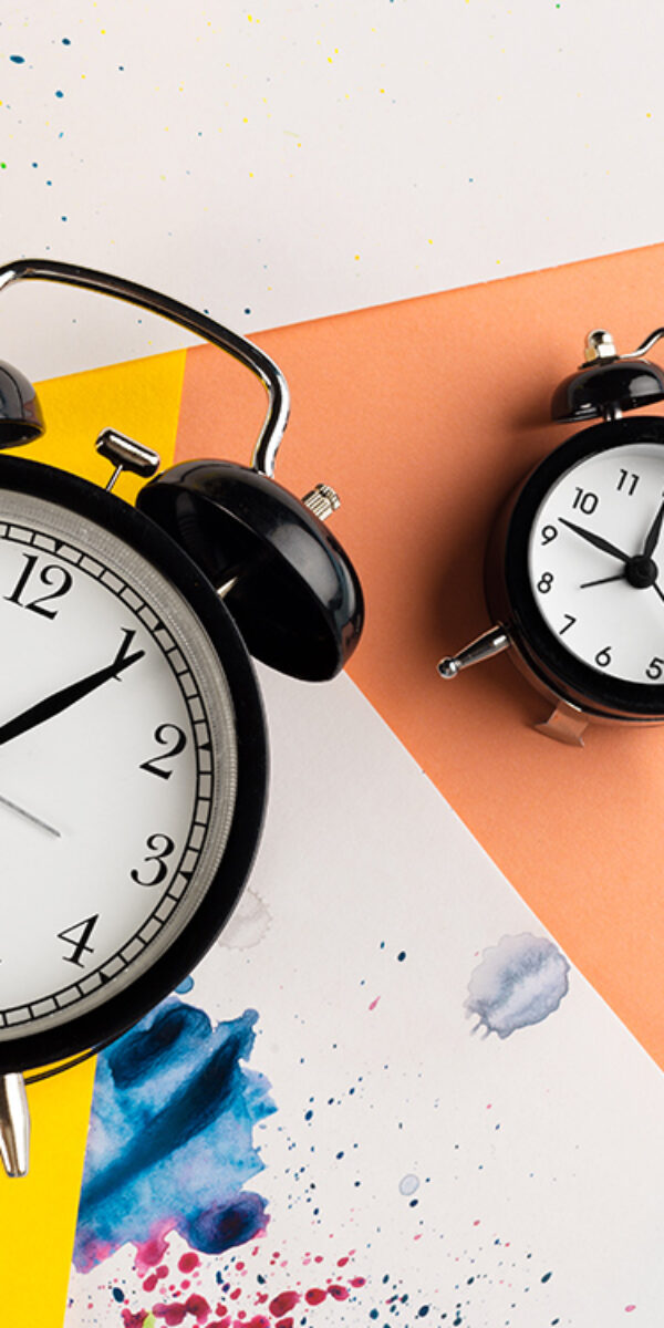 Vintage black alarm clock on a color block background