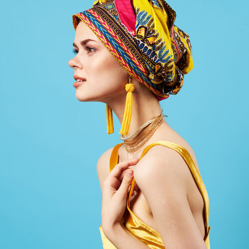 woman in multicolored turban luxury ethnicity blue background. High quality photo