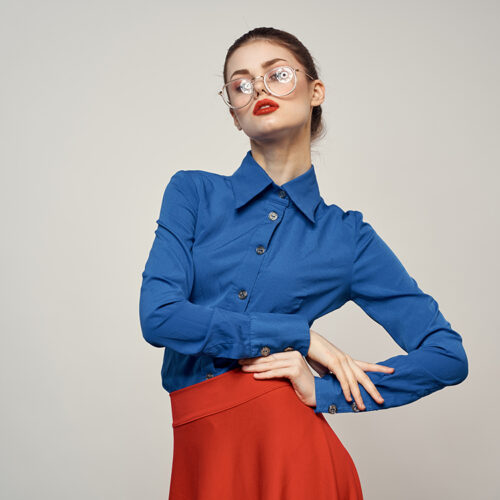 woman model in blue shirt and red skirt glasses beautiful face makeup studio. High quality photo